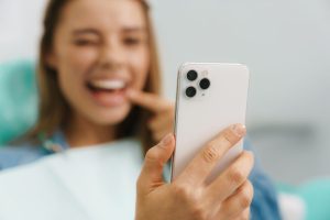 ragazza si fa un selfie con la app di dental monitoring per le terapie ortodontiche